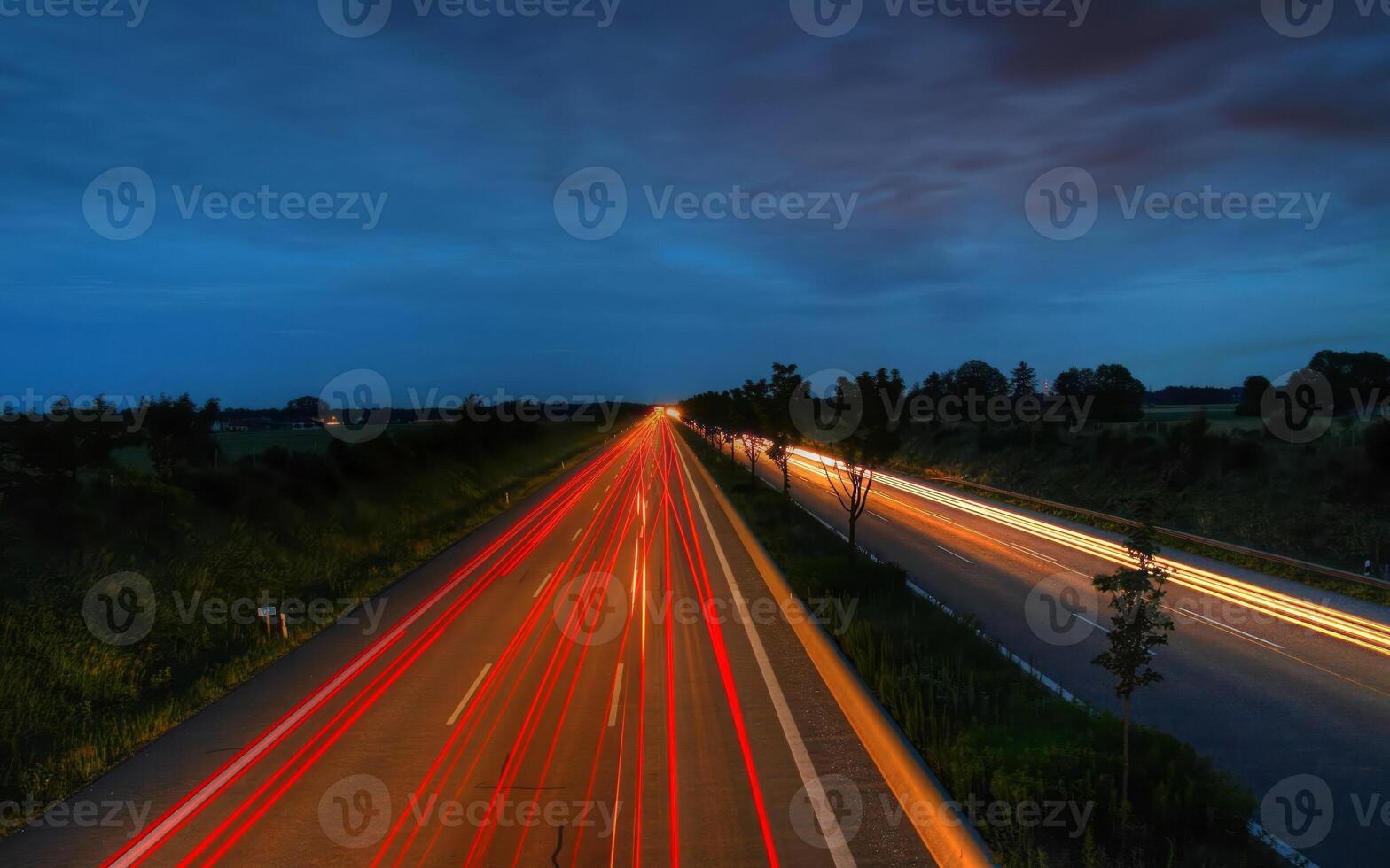 Tranquil Roadway Beneath a Cloudy Sky with Lush Greenery photo