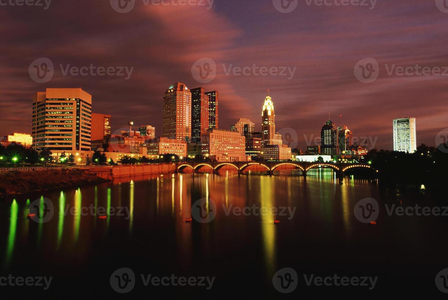 Serene Dusk Reflection of Skyscrapers on a Tranquil Lake Under a Cloudy Sky photo
