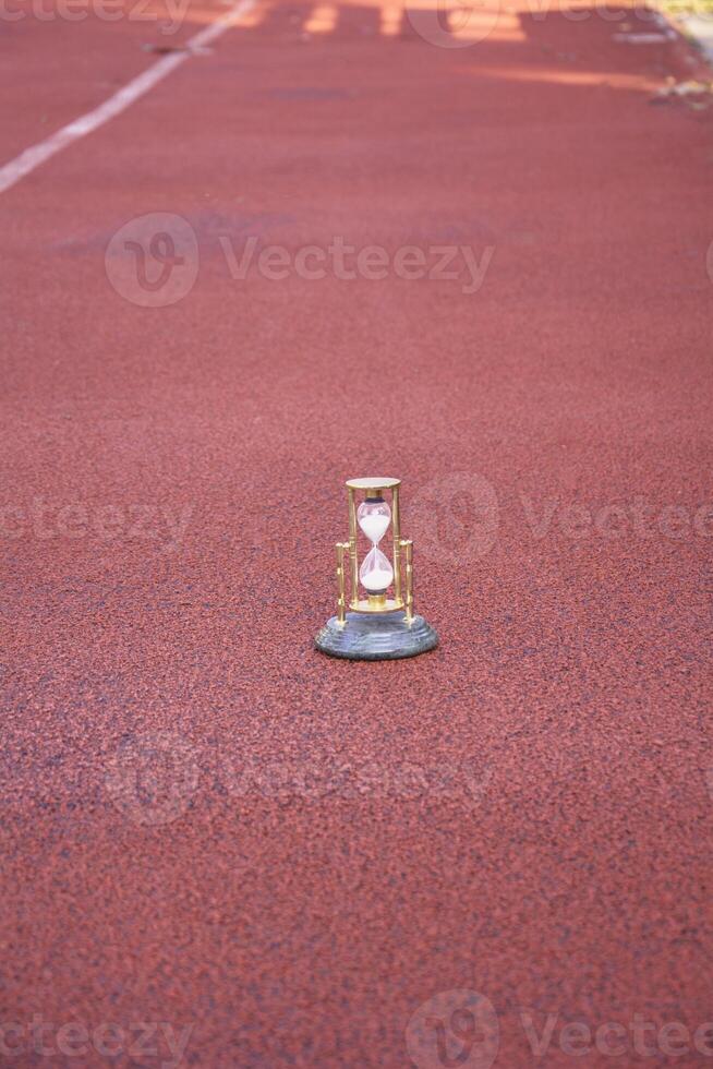 A small hourglass on the ground in a running track photo
