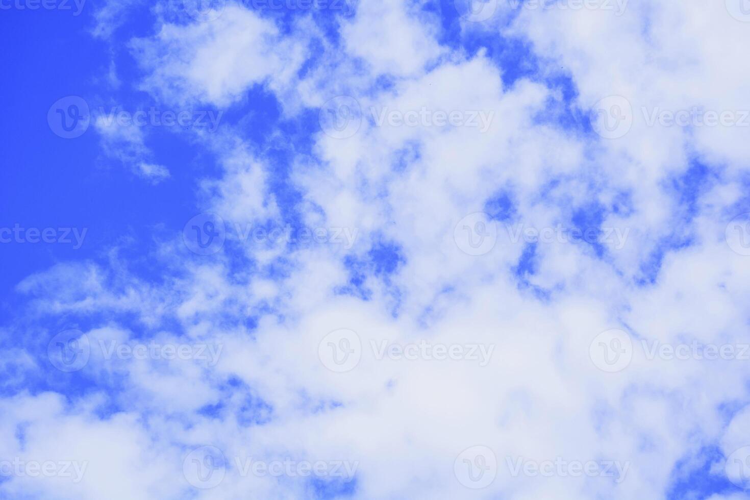A blue sky with white clouds and a kite flying photo