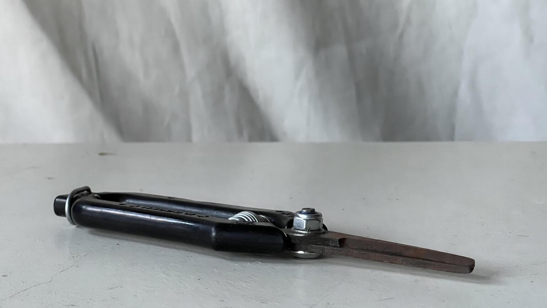 Metal compass resting on a white table with a textured background photo