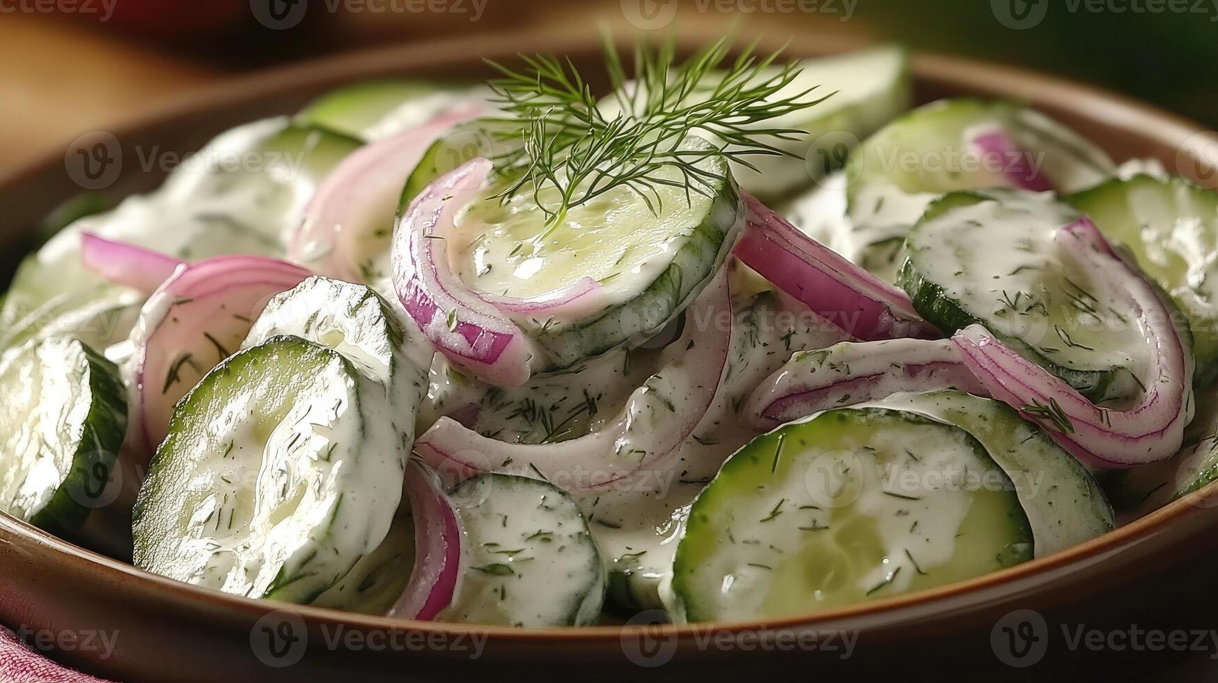 Creamy cucumber salad with red onions and fresh dill in a bowl photo