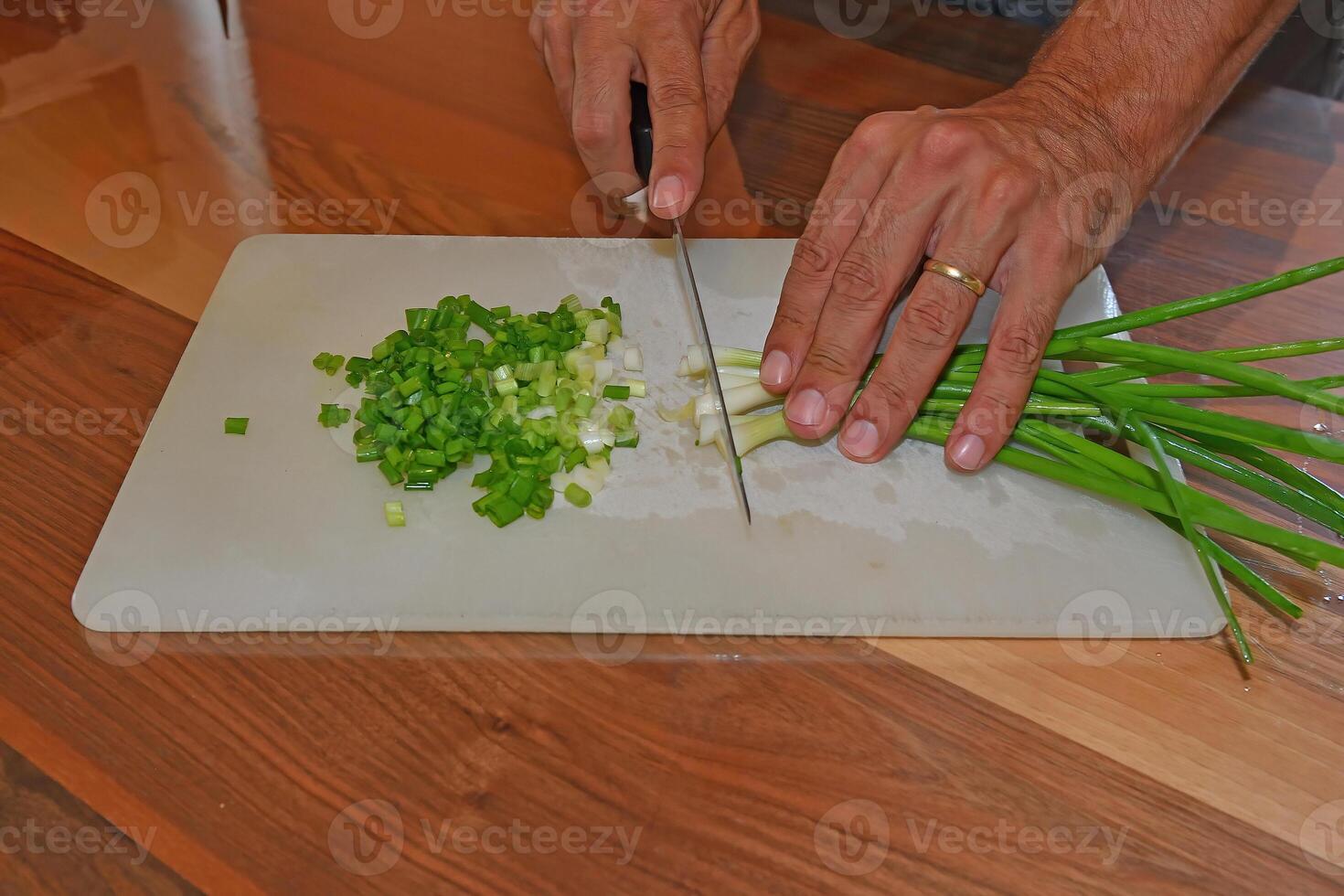 Chopping green onions for salad. photo