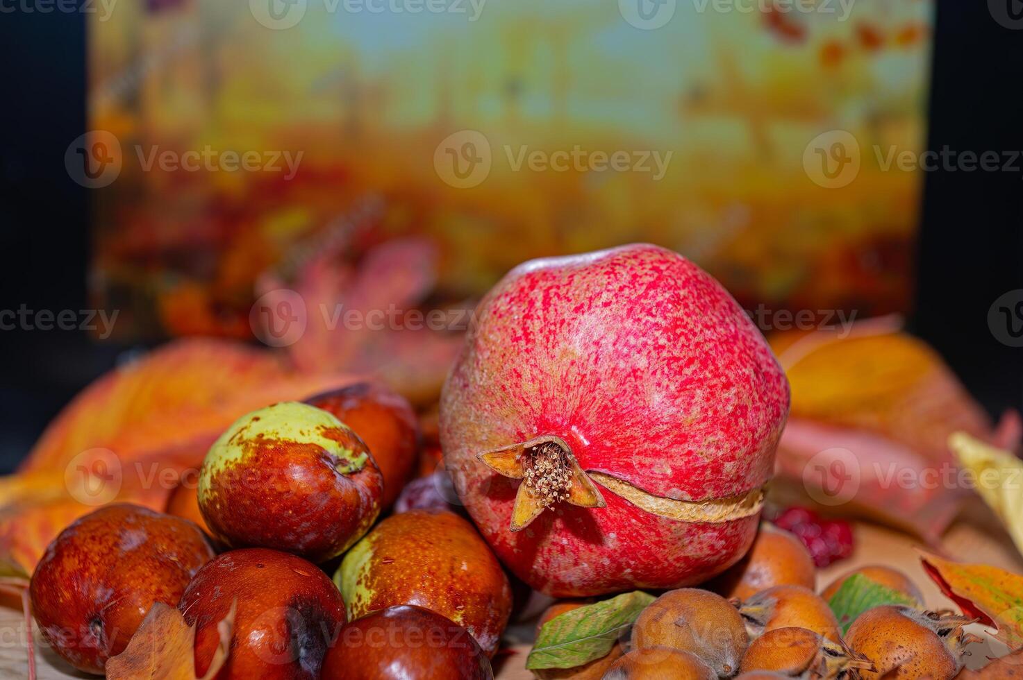 Fresh ripe organic medlar fruit, pomegranate and jujube among autumn leaves. photo