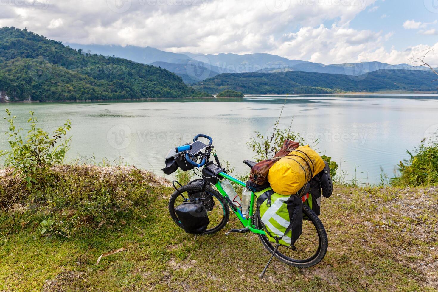 tourist bicycle stands on the bank of the river photo