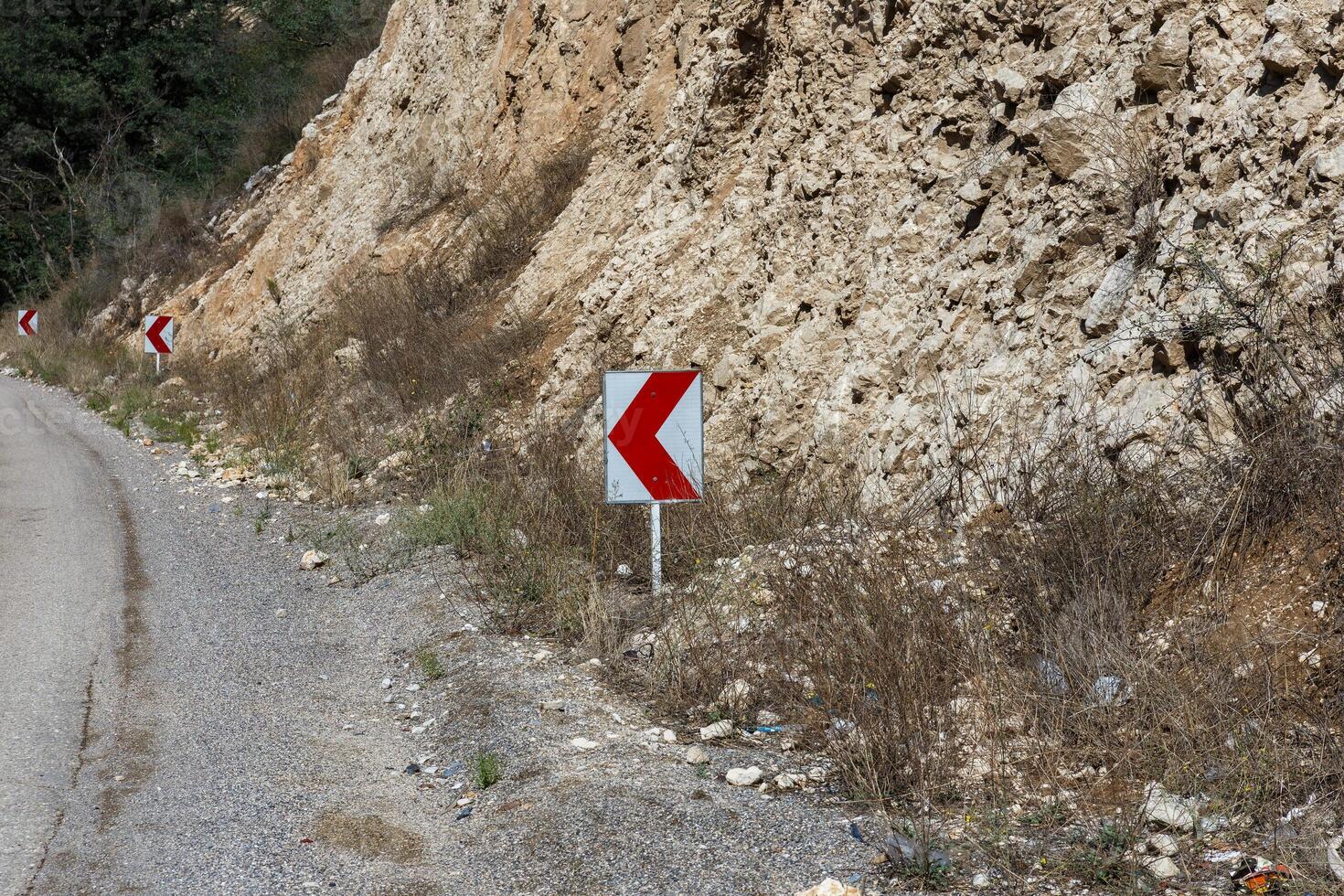 Curved road sign indicating a sharp turn in mountainous terrain of Iran photo