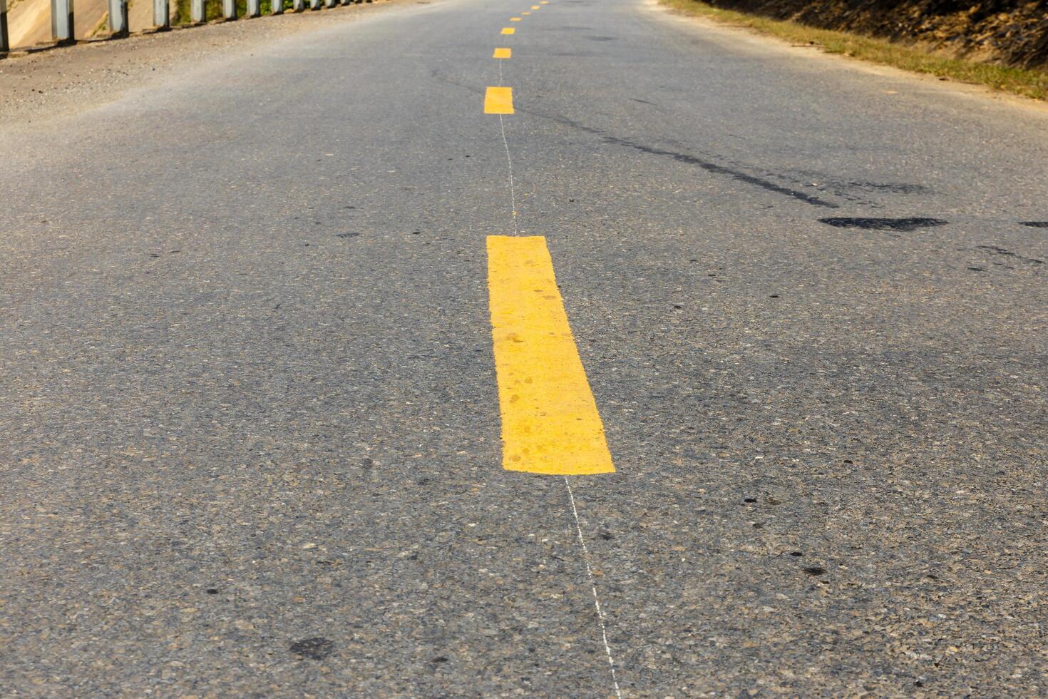 yellow broken line on asphalt road photo
