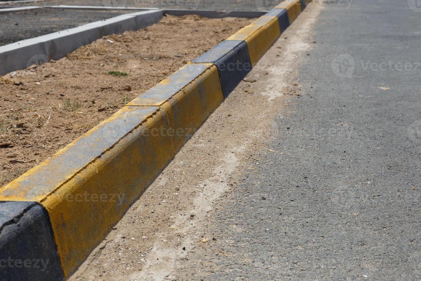 A yellow and black striped curb photo