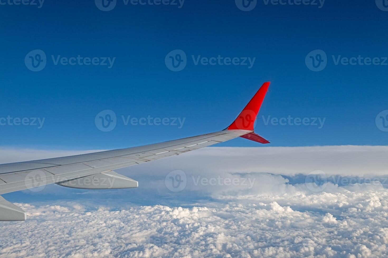 Blue sky, white clouds and aircraft wing from the aircraft window on a beautiful sunny day. photo