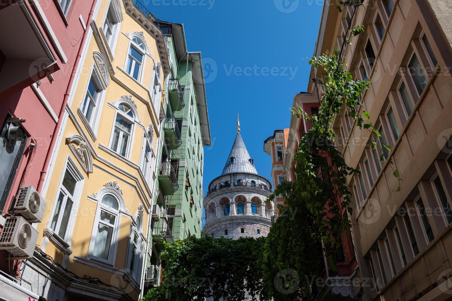 Galata Tower, one of the side streets of Beyoglu. Stone historical building built by Genoese, Byzantine and Ottoman. photo