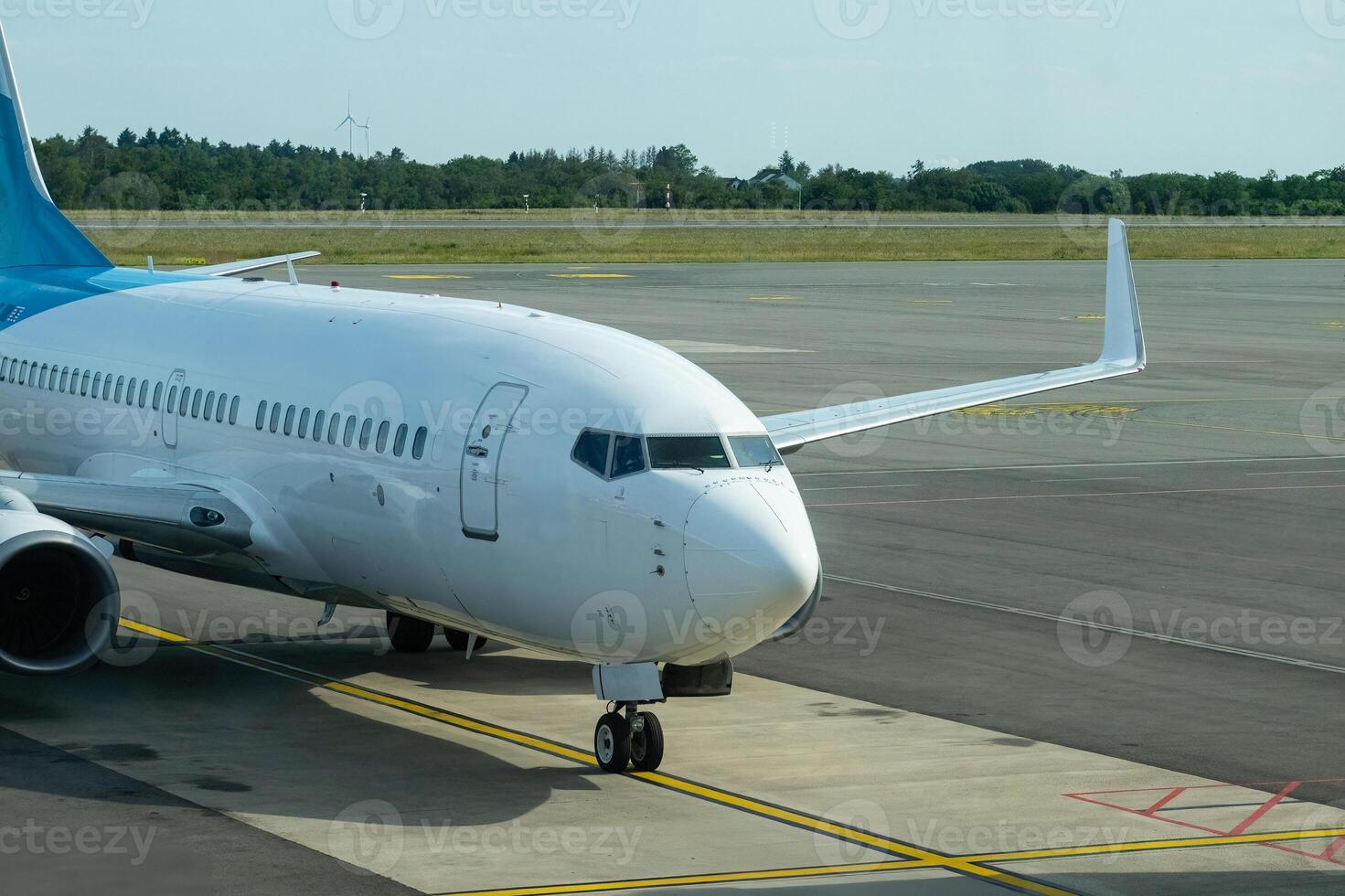 Passenger aircraft entering the platform at an airport. Woodland and sky in the background. photo