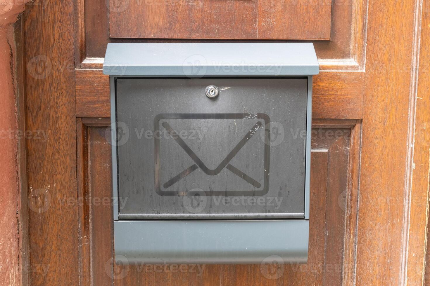 Metal mailbox on the wooden door of a house. photo