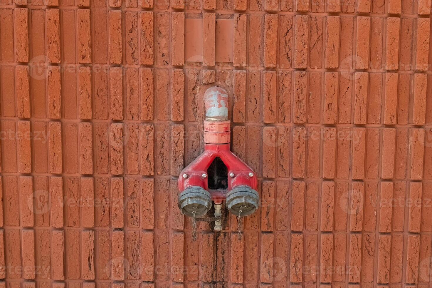Fire hydrants on the background of a red brick wall. photo