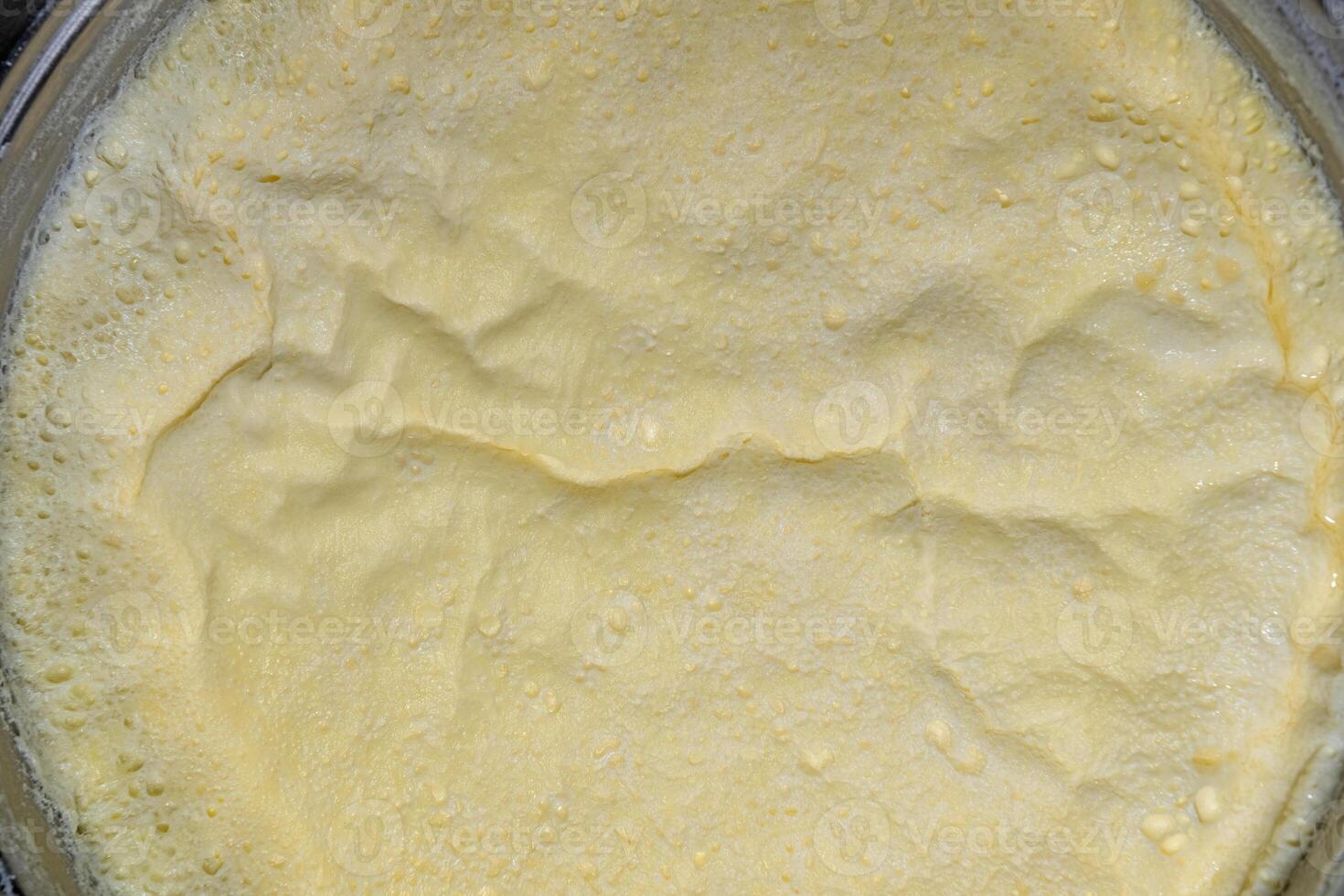 A layer of cream formed on milk boiled in a saucepan. Close-up. photo