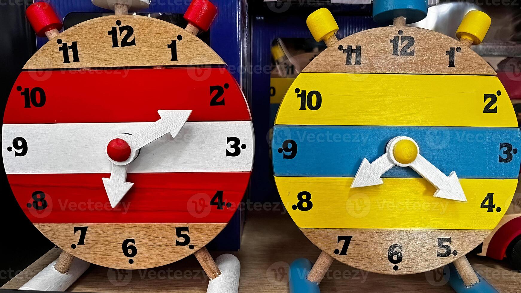 Handmade colorful wooden clocks at the stand where various products are sold. photo