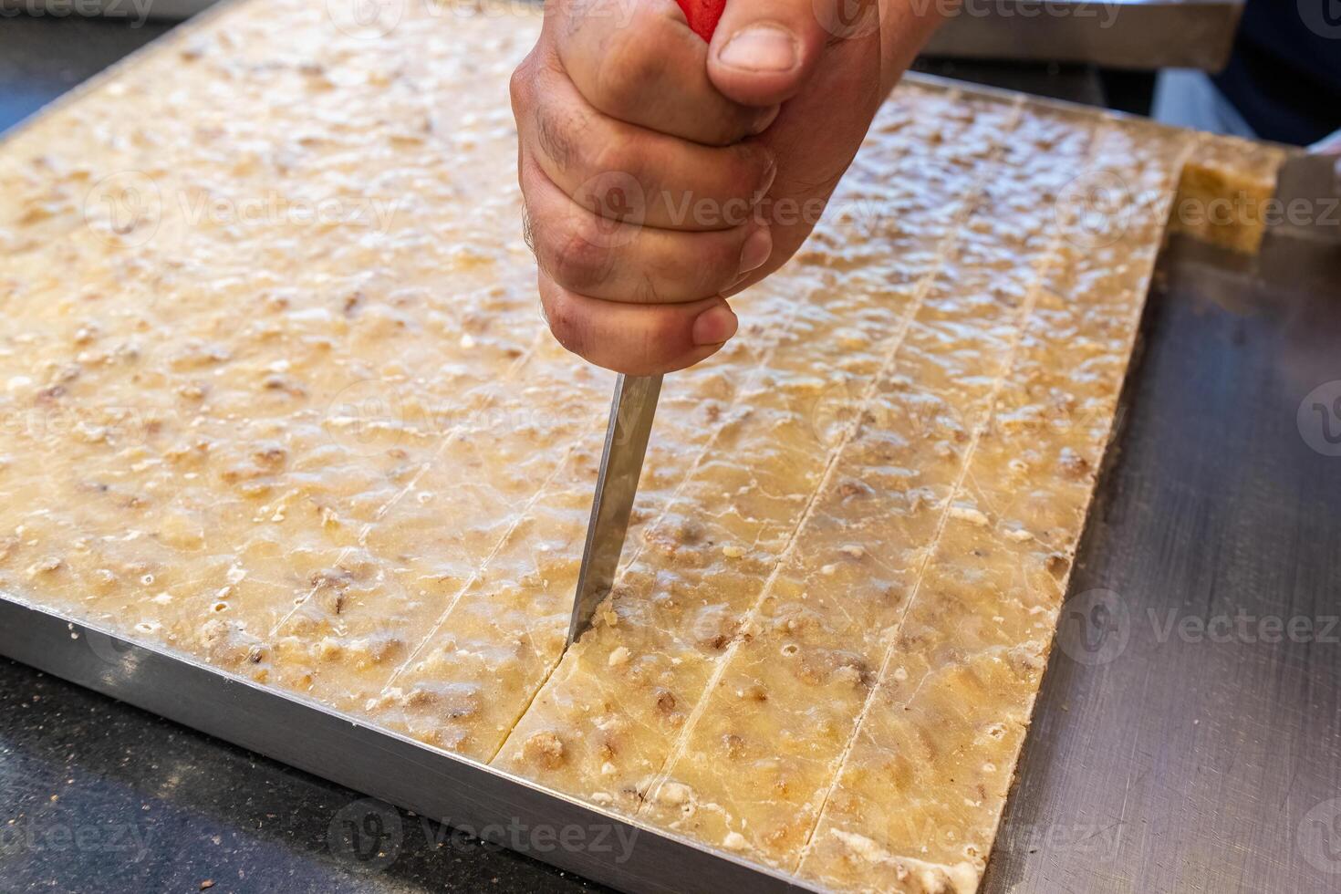Slicing a dessert made of walnut, semolina and sugar. Walnut paste. Burdur, Turkey. photo