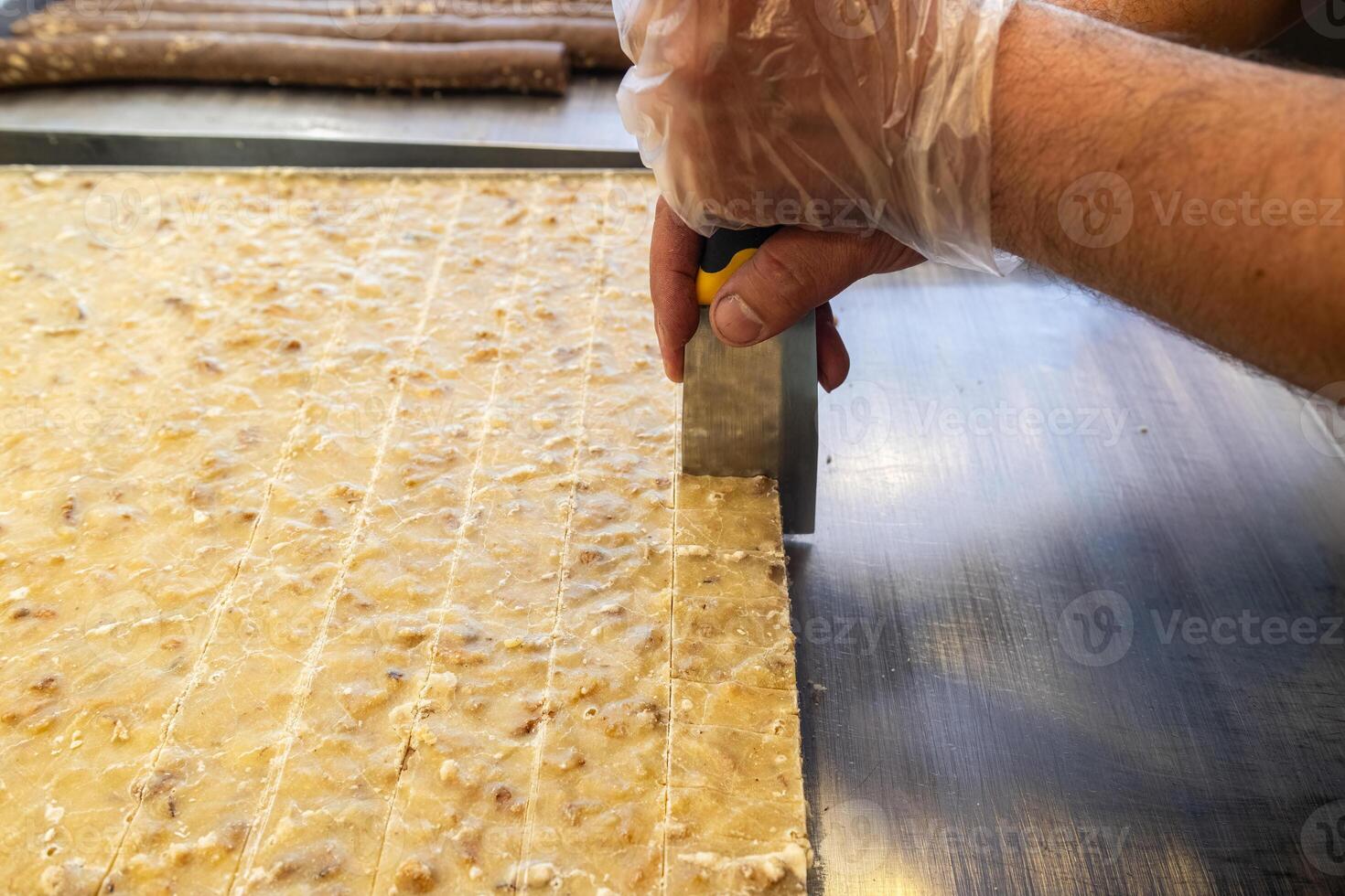 Slicing a dessert made of walnut, semolina and sugar. Walnut paste. Burdur, Turkey. photo