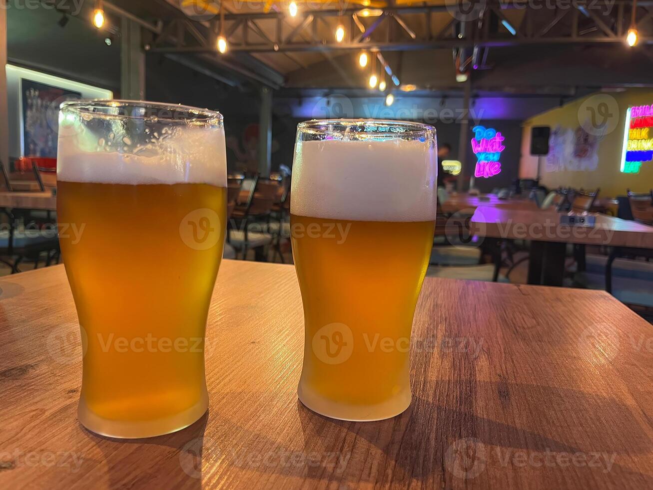 Two glasses of beer on the table in the pub. photo