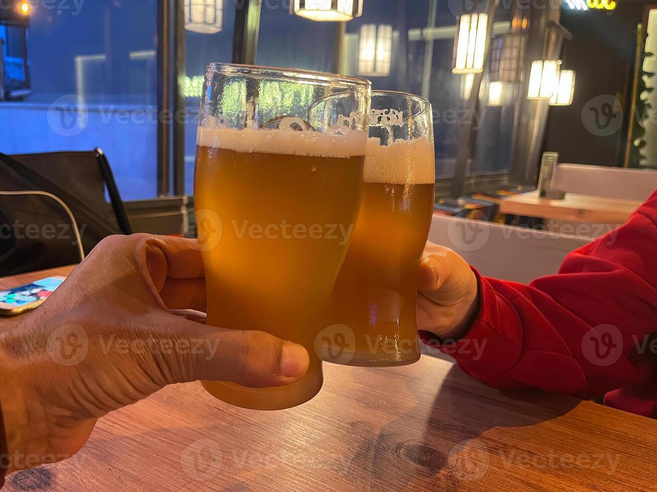 Two people in a pub, drinking a beer. photo