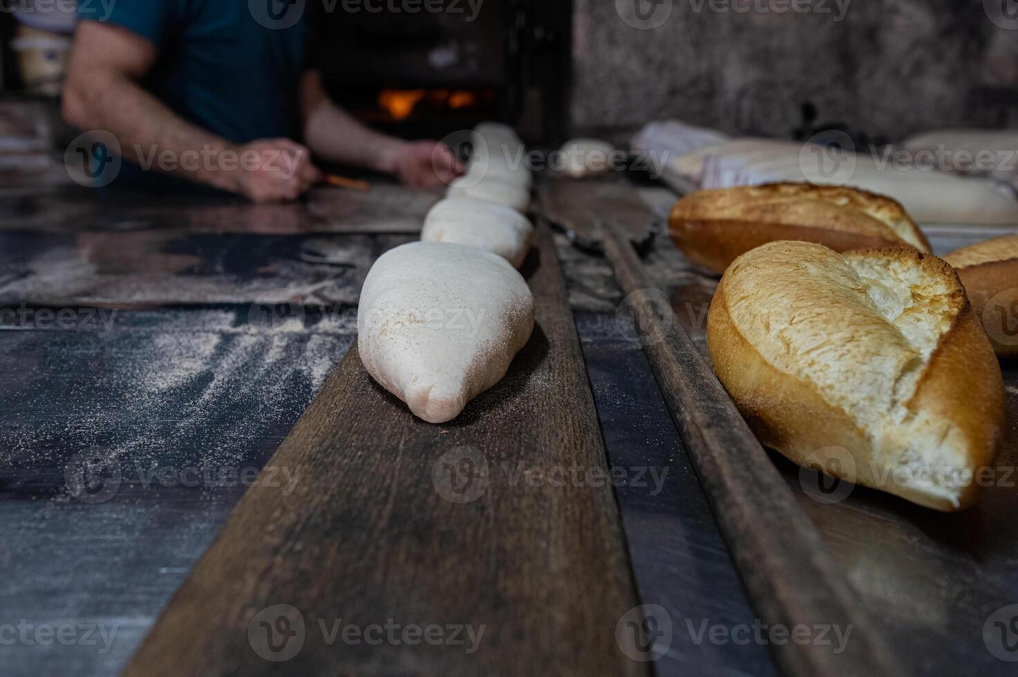 Bakery, bread making. When the baker gives the bread dough to the oven. Turkish bread production process. photo