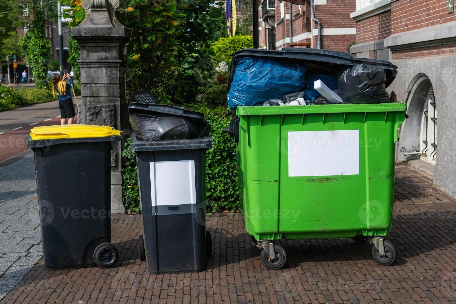 Full rubbish bins on the pavement. photo