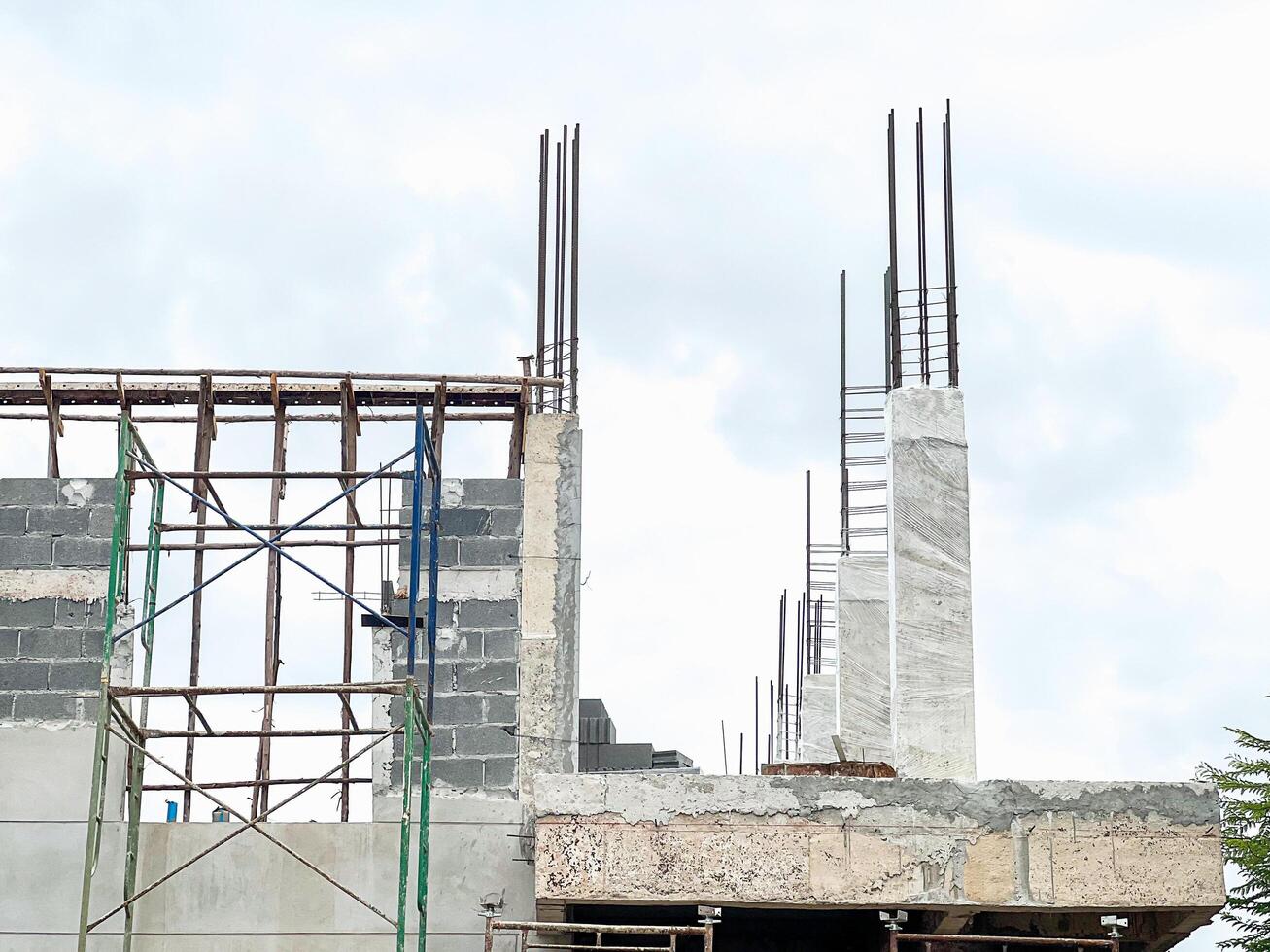 Building Construction Site with Scaffolding, Steel Structures, Material Piles, and Construction Equipment photo