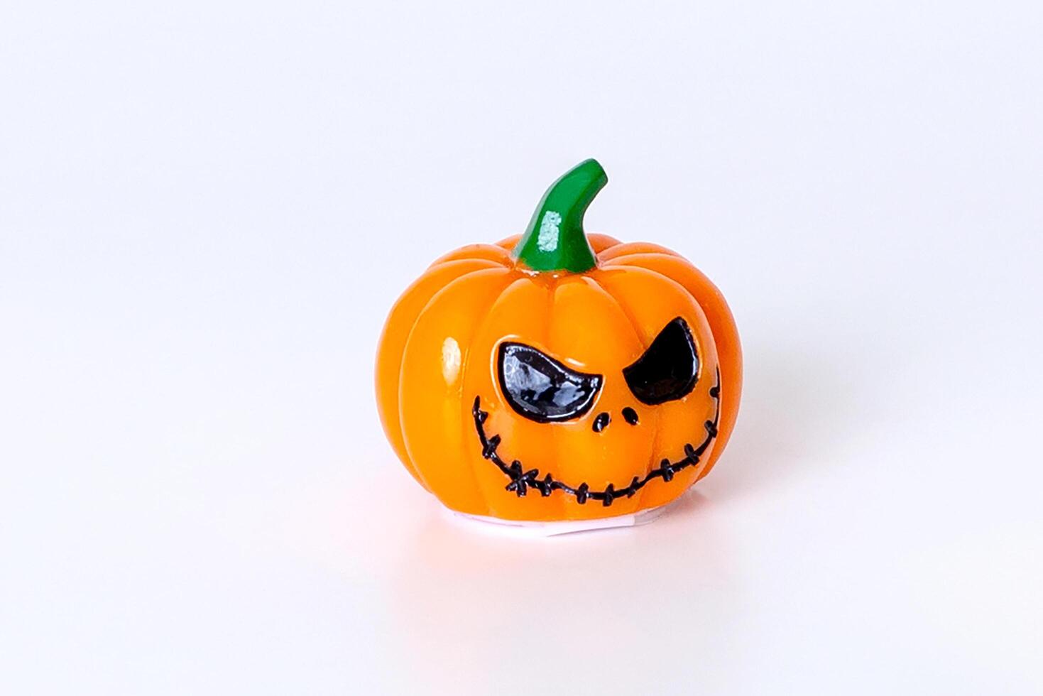 Spooky halloween pumpkin with scary face on white background photo