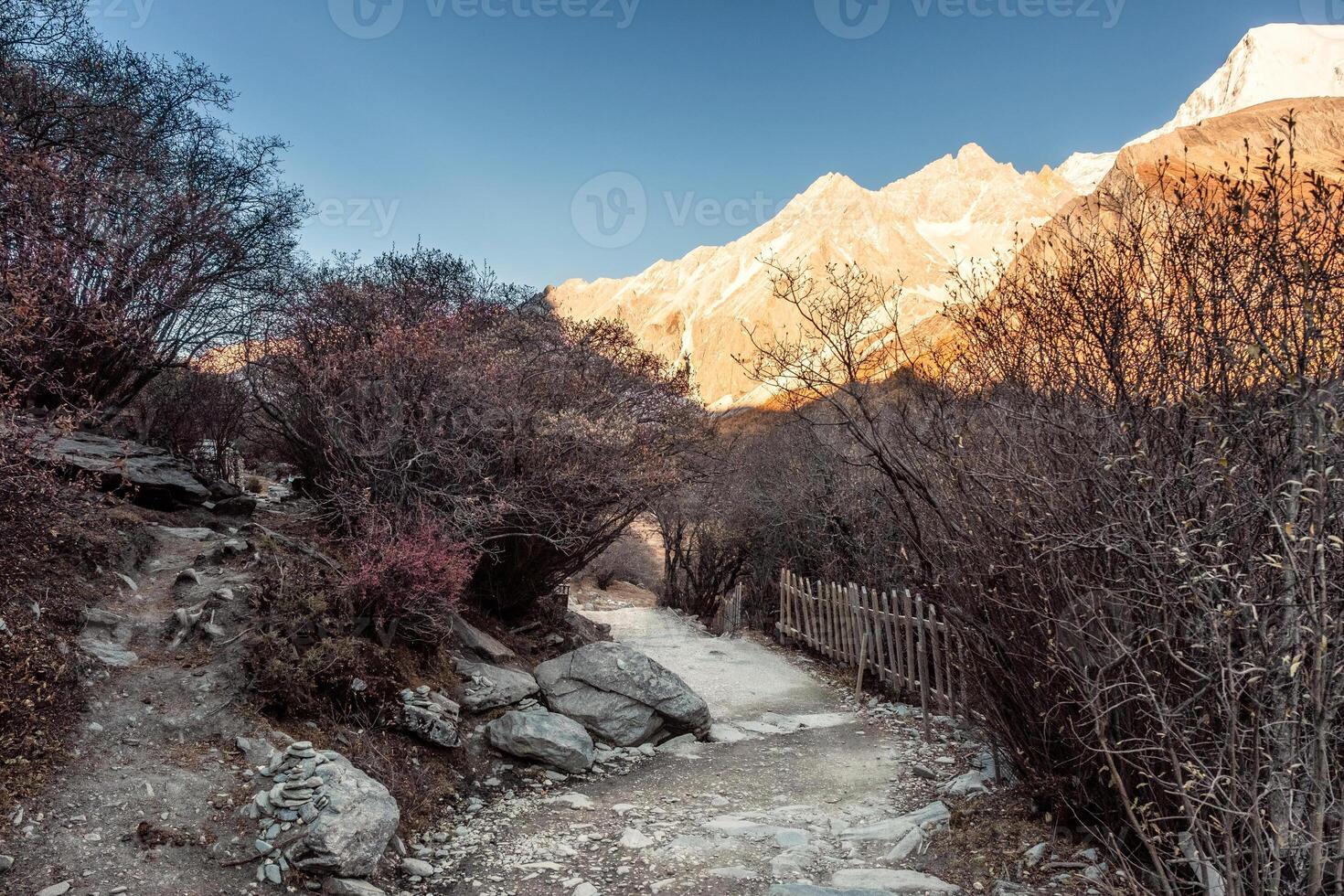 Trail in autumn valley with sunrise on mountain range photo