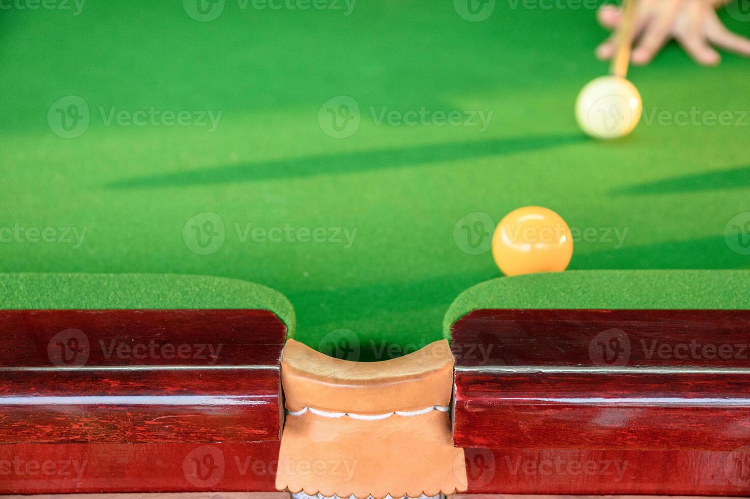Man's hand playing snooker in bar with snooker ball photo