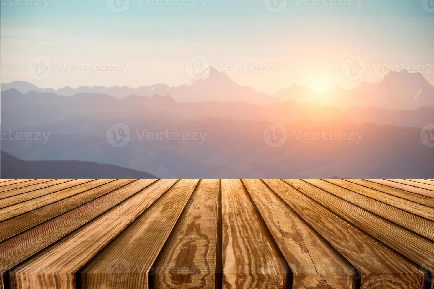 Brown wooden table top on blurred peak on mountain range with sunrise photo