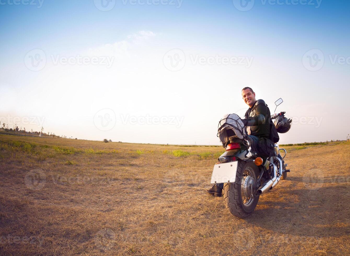 Biker on the country road against the sky photo