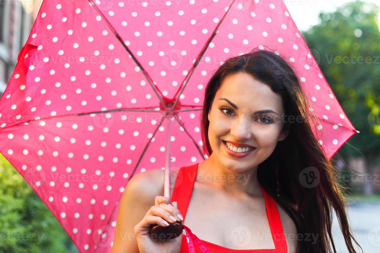 Portrait of beautiful young girl walking with umbrella photo