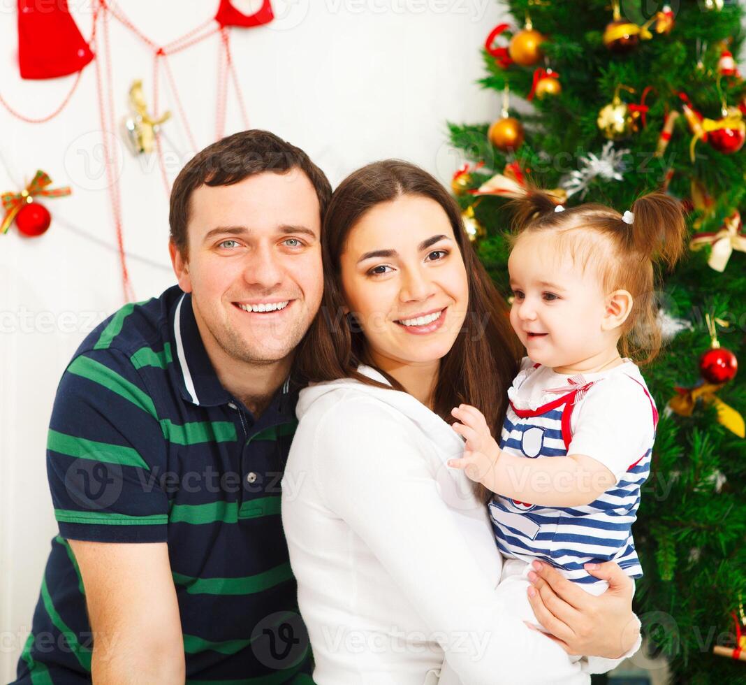 Happy family with Christmas baby near the Christmas tree photo