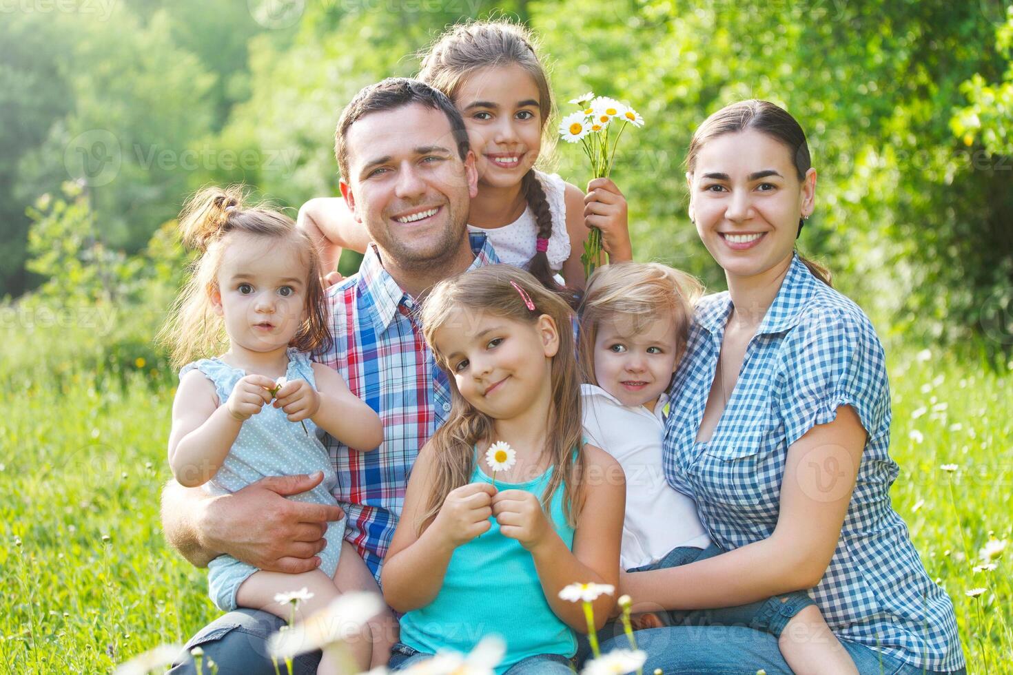 Happy young family with four children outdoors photo