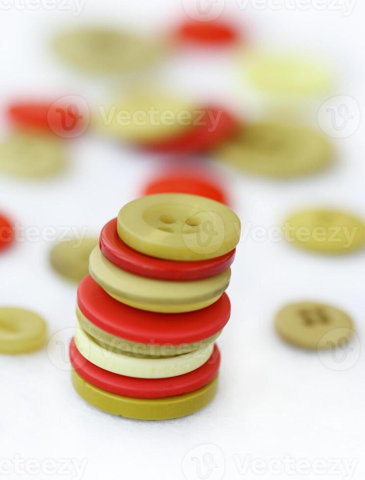 a stack of buttons on a white surface photo