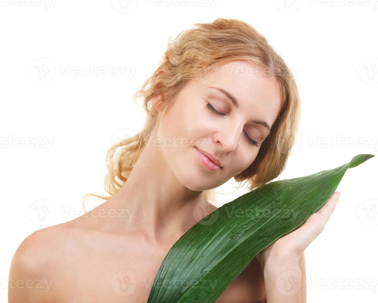 Portrait of the beauty young blond woman with green leaf photo
