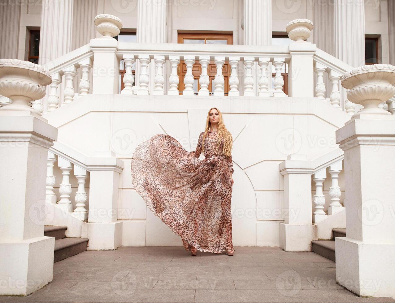 Beautiful blond woman in long dress outdoors photo