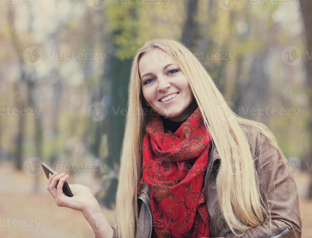 Portrait of a smiling beautiful woman texting sms photo