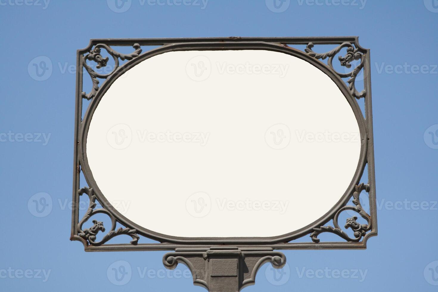 a white sign with a circular frame against a blue sky photo