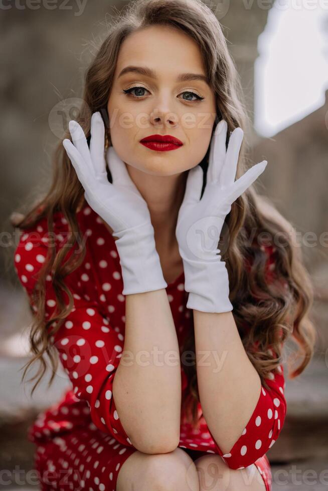 Elegant woman wearing white gloves and red polka dot dress photo