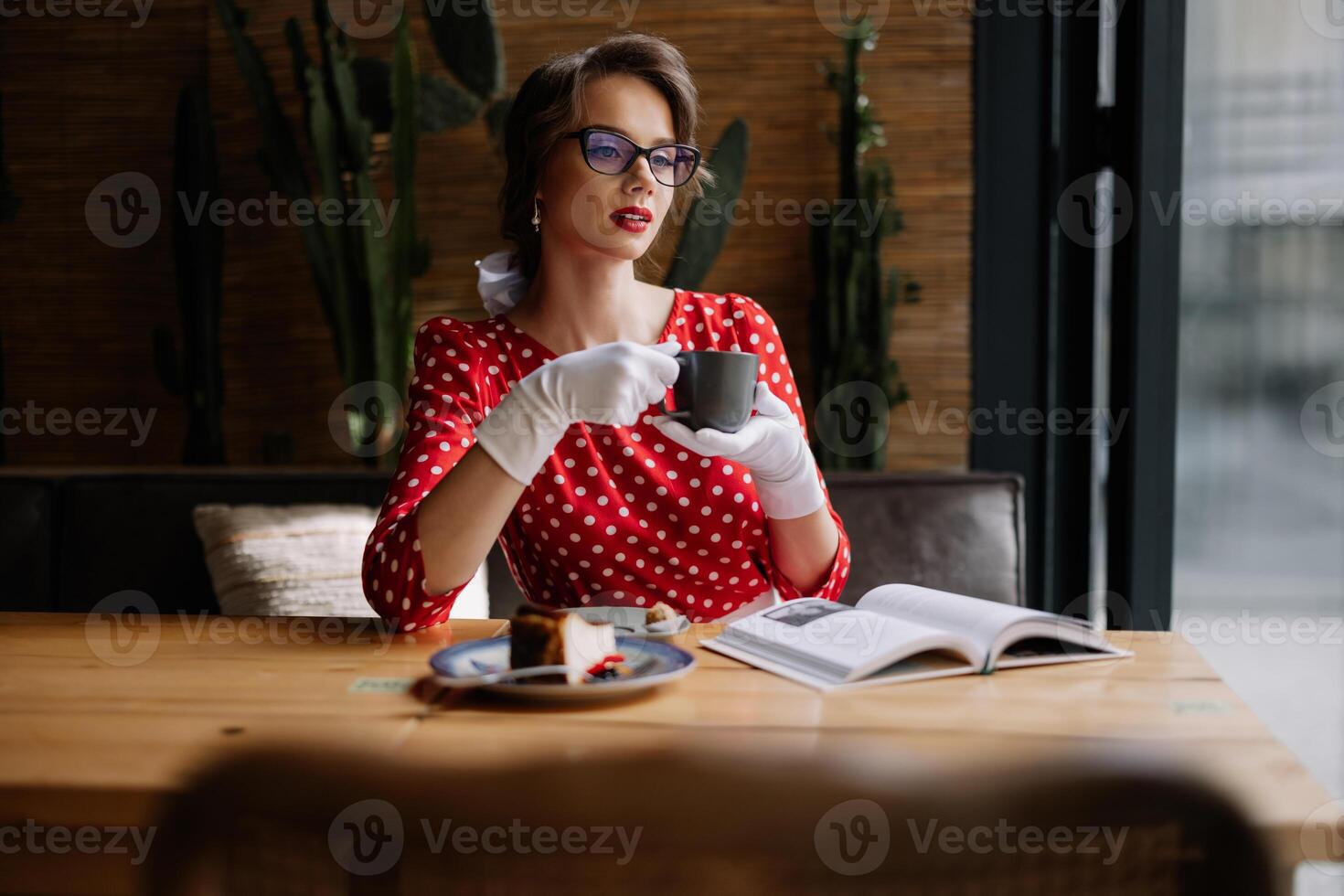 Elegant woman enjoying coffee and reading in retro cafe photo