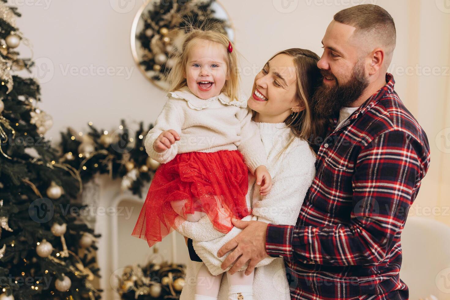 Happy family holding smiling daughter celebrating christmas at home photo