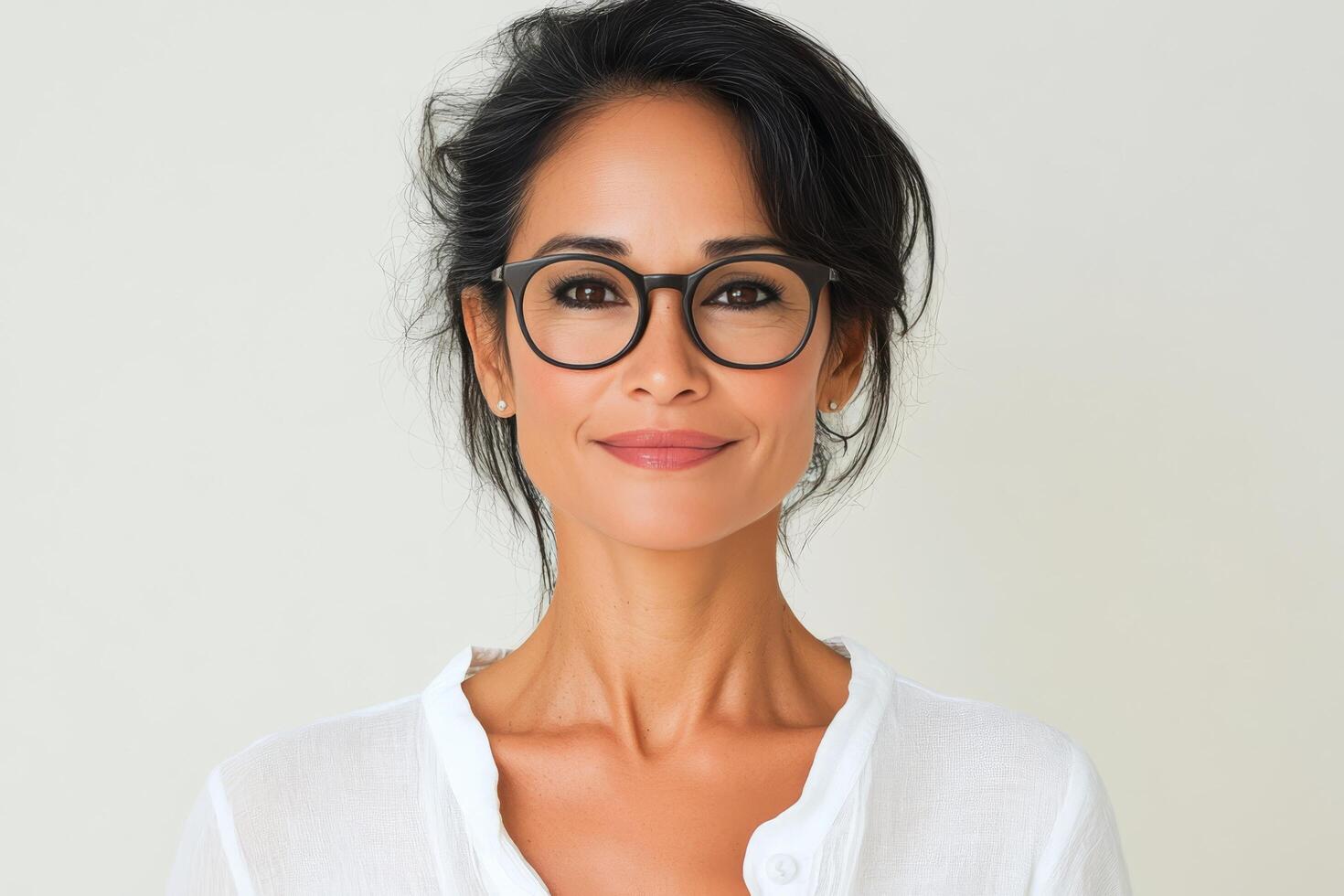 Portrait of a woman wearing glasses in a neutral tone setting with a serene expression photo