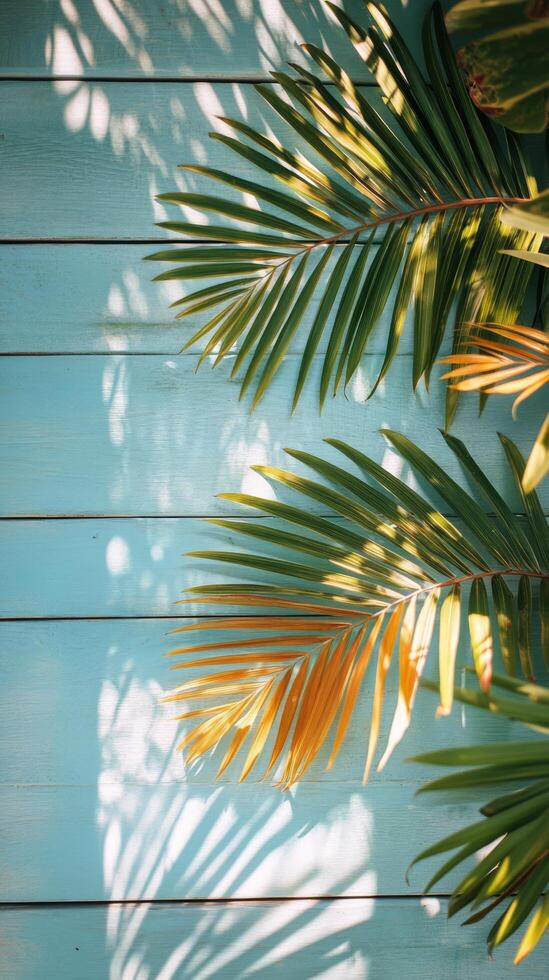 Palm leaves casting shadows on a blue wooden background in bright daylight photo