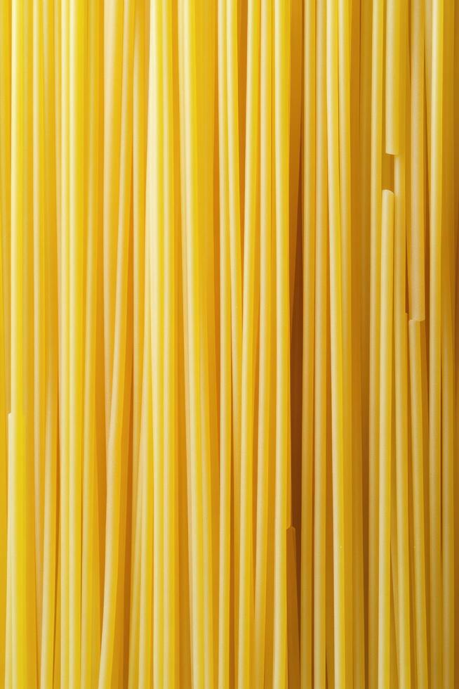 Long strands of yellow pasta displayed against a neutral background for culinary use photo
