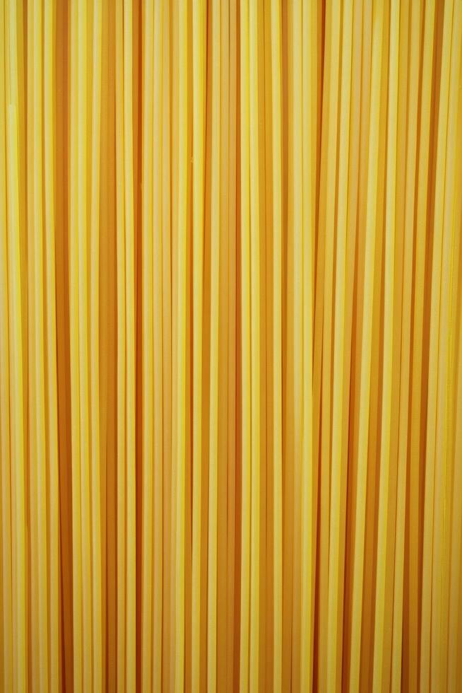Long strands of yellow pasta displayed against a neutral background for culinary use photo