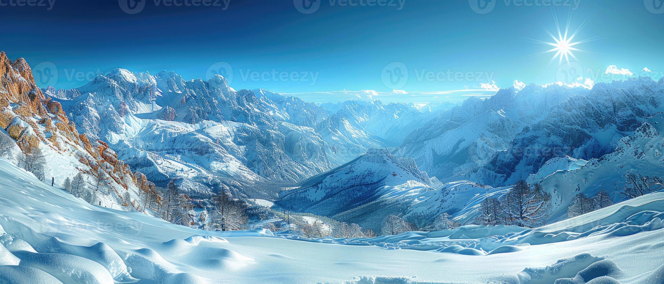 Majestic Snowy Mountain Range with Sunburst and Blue Sky photo