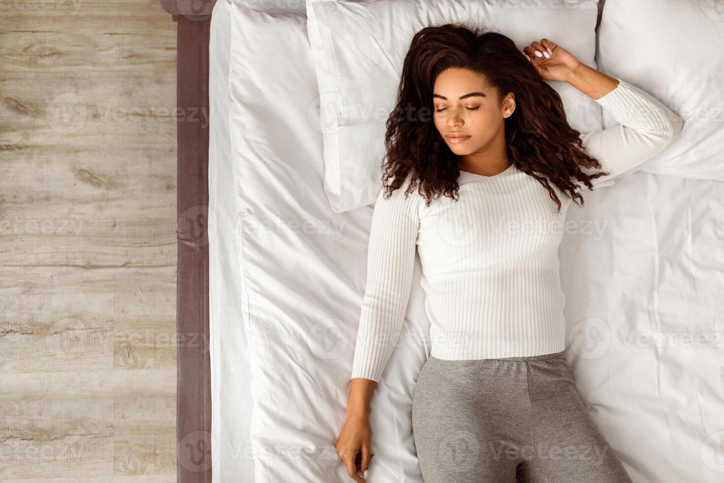 Top above high angle view of calm young black woman sleeping well on the back. African American lady resting, enjoying fresh cotton bedding, soft pillow and comfy mattress, free copy space, banner photo