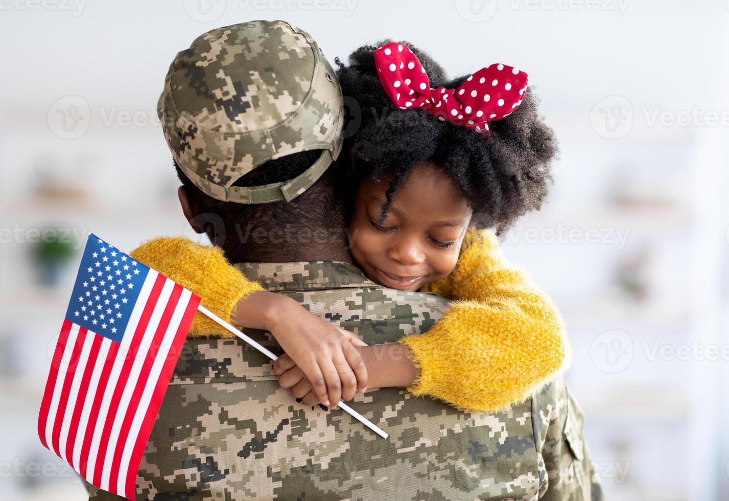 Happy Little Black Daughter Hugging Her Soldier Dad After He Came Back Home From US Army, Smiling Girl Holding American Flag And Embracing Father In Military Uniform, Celebrating Reunion With Daddy photo