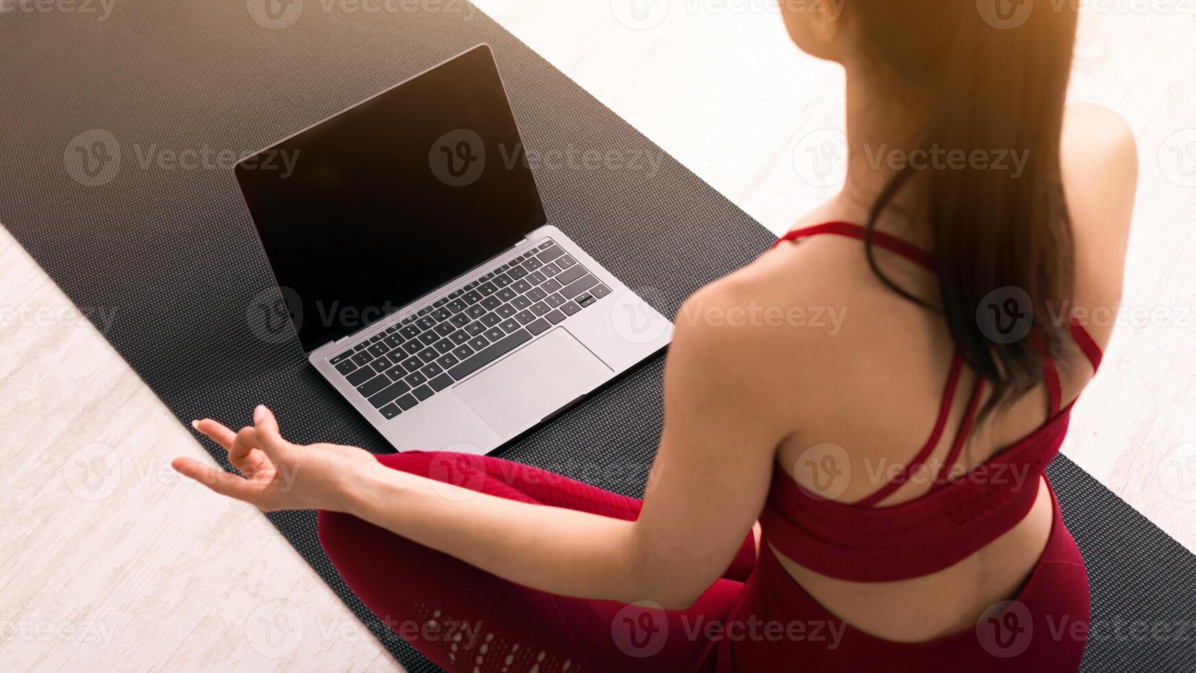 Self isolation during pandemic. Young woman doing breathing exercises or meditation following online yoga tutorial, above view. Mockup for design on laptop screen photo
